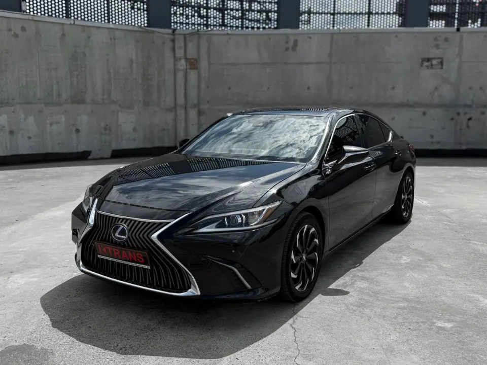 Black 2019 Lexus ES300 Hybrid with a KTRANS plate on a concrete parking garage roof