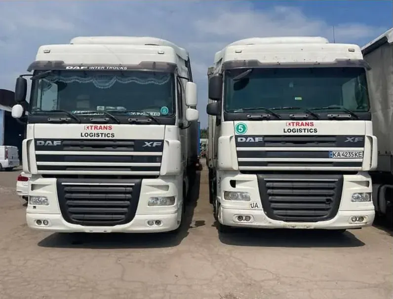Two white DAF XF tractor units with KTRANS LOGISTICS on the cabs, front view, on a concrete yard